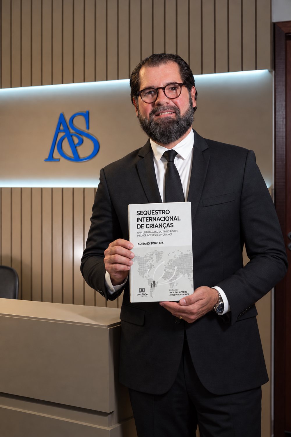 Dr. Adriano Sobreira segurando o livro Sequestro Internacional de Crianças, publicado pela Editora Dialética